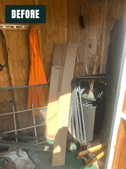 Shed filled with boards, a bin, and old tools